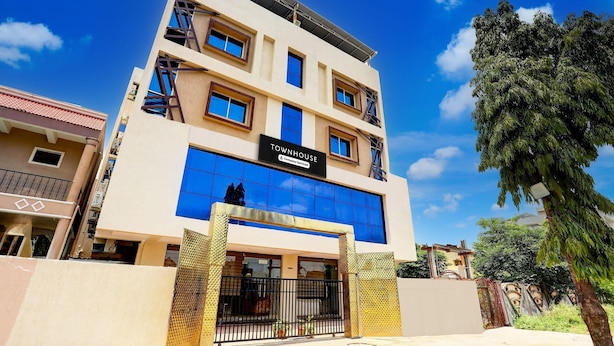 A multi-story building with a sign reading 'TOWNHOUSE & Company Serviced Apartments.'