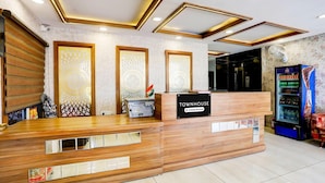 A reception desk with a 'Townhouse' sign, a fax machine, and a vending machine.