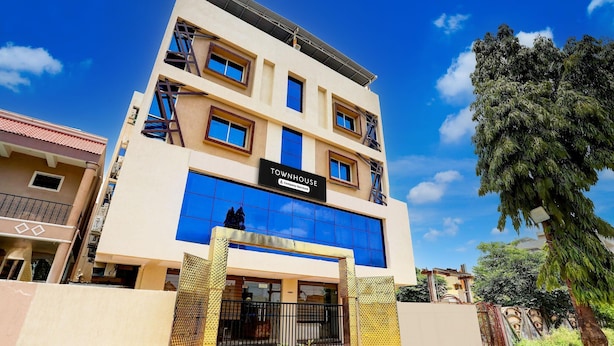 A multi-story building with a sign reading 'TOWNHOUSE & Company Serviced Apartments.'
