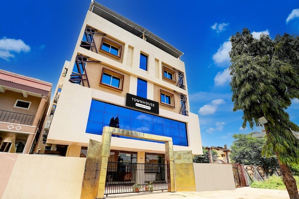 Un edificio de varios pisos con un letrero que dice 'TOWNHOUSE & Company Serviced Apartments'.