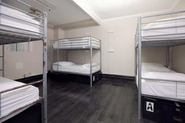 A room with bunk beds, a wooden floor, and a white wall. - Glebe Terraces (Glebe)