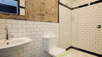 Un baño con lavamanos, inodoro y ducha.