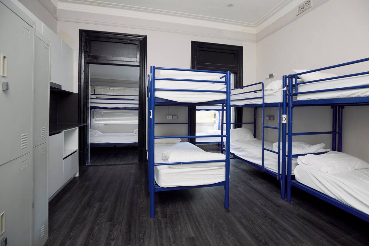 A room with bunk beds, a wardrobe, and a television.