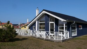 A modern house with a white porch, a blue exterior, and a red roof. - 4 Star Holiday Home in Grossenbrode (Grossenbrode)