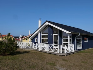 A modern house with a white porch, a blue exterior, and a red roof. - 4 Star Holiday Home in Grossenbrode (Grossenbrode)