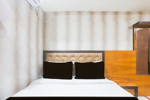 Un dormitorio con cama, cabecera, armario y pared con textura.