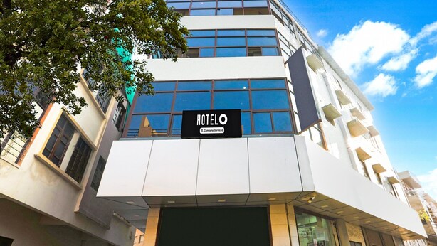 Um edifício moderno de hotel com uma placa que diz 'HOTELO' e uma etiqueta de serviço da empresa.