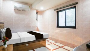 Casa de banho moderna com cama, janela e ar condicionado fixado na parede.