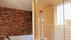 A modern bathroom with a wooden wall, a glass shower enclosure, and a bathtub. - Suite Marrakech - Sauna - Jacuzzi - Swimming pool - Bicycle - ardèche (Saint-Martin-d'Ardèche)
