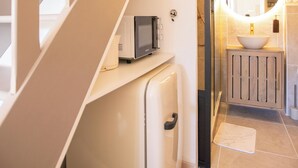 A modern interior with a staircase, a compact kitchenette, and a bathroom with a round mirror. - Suite Marrakech - Sauna - Jacuzzi - Swimming pool - Bicycle - ardèche (Saint-Martin-d'Ardèche)