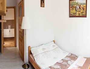 A bedroom with a single bed, a bedside lamp, a radiator, and a framed painting on the wall. - Double Room, Sauna, Masuria (Ruciane-Nida)