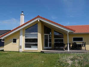 A single-story house with a red-tiled roof, large windows, and a covered patio area. - 4 Star Holiday Home in Grossenbrode (Grossenbrode)