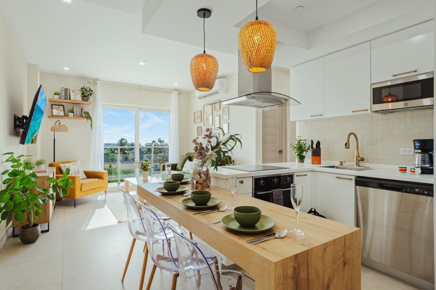 A modern kitchen with a central island, stainless steel appliances, and a dining area with a sofa and chairs.