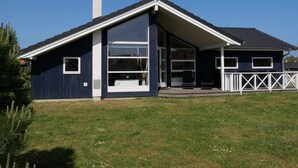 A modern house with a large garage, a covered porch, and a chimney. - 4 Star Holiday Home in Grossenbrode (Grossenbrode)