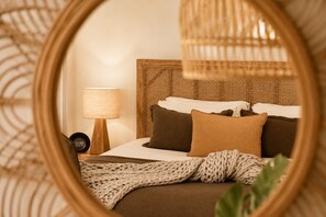 A bed with a woven headboard, a bedside lamp, and a knitted throw blanket. - Cape Byron Retreat (Skinners Shoot)