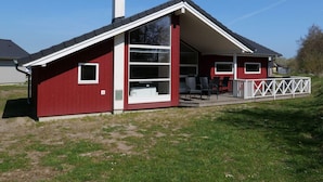 A red building with a white porch, a chimney, and a large window. - 4 Star Holiday Home in Grossenbrode (Grossenbrode)