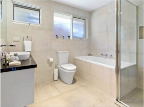 Ein Badezimmer mit Toilette, Badewanne und Dusche.