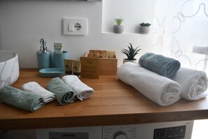 A bathroom counter with towels, toiletries, and a soap dispenser. - G studio near sea central Rapallo/ near Portofino (Rapallo)