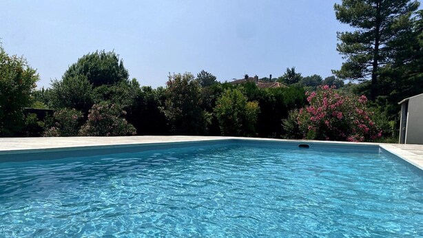A rectangular swimming pool with clear blue water, surrounded by a white deck and lush greenery. - Magnificent Family Villa Near the Ceze River (Saint-Ambroix)