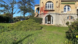 A large, historic building with a prominent archway entrance, a balcony, and a stone facade. - Magnificent Family Villa Near the Ceze River (Saint-Ambroix)