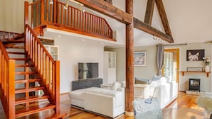 A spacious living area with a wooden staircase, white sofas, and a fireplace. - Bickley Tree Stay (Bickley)