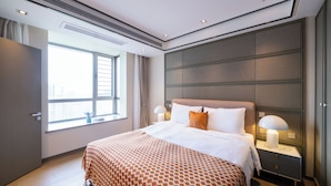 A hotel room with a large bed, bedside lamps, a window, and a view of the city. - Tyms High Serviced Residence Shanghai Caohejing (Shanghai)