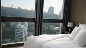 A hotel room with a large window, a bed, a nightstand, and a lamp. - Unixx South Pattaya Condominium (Pattaya)