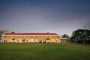 A large building with a red roof and multiple windows, surrounded by a grassy area. - Manohari Tea Trails & Resort Dibrugarh (Dibrugarh)