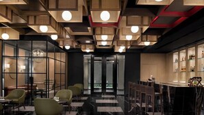 Un interior moderno con una zona de bar, asientos y vistas a través de un ventanal.