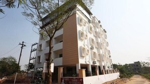 Un edificio residencial de varios pisos con un estilo arquitectónico moderno, que presenta un techo plano y una fachada simétrica.