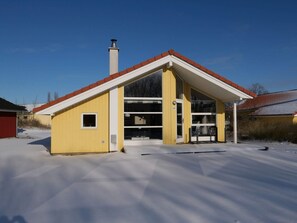 A yellow building with a red roof, large windows, and a chimney. - Cosy Coastal Stay for 6 Guests (Grossenbrode)