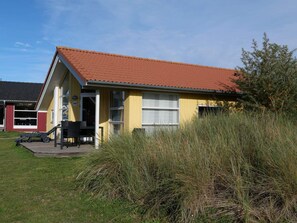 A yellow building with a red roof, a visible door, and a window. - Cosy Coastal Stay for 6 Guests (Grossenbrode)