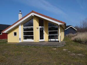 A yellow building with a red roof, large windows, and a number 147 sign. - Cosy Coastal Stay for 6 Guests (Grossenbrode)