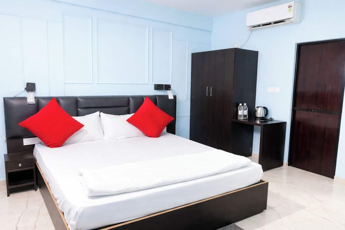 Une chambre d’hôtel équipée d’un lit, d’une armoire, d’une table de chevet et d’un appareil de climatisation.
