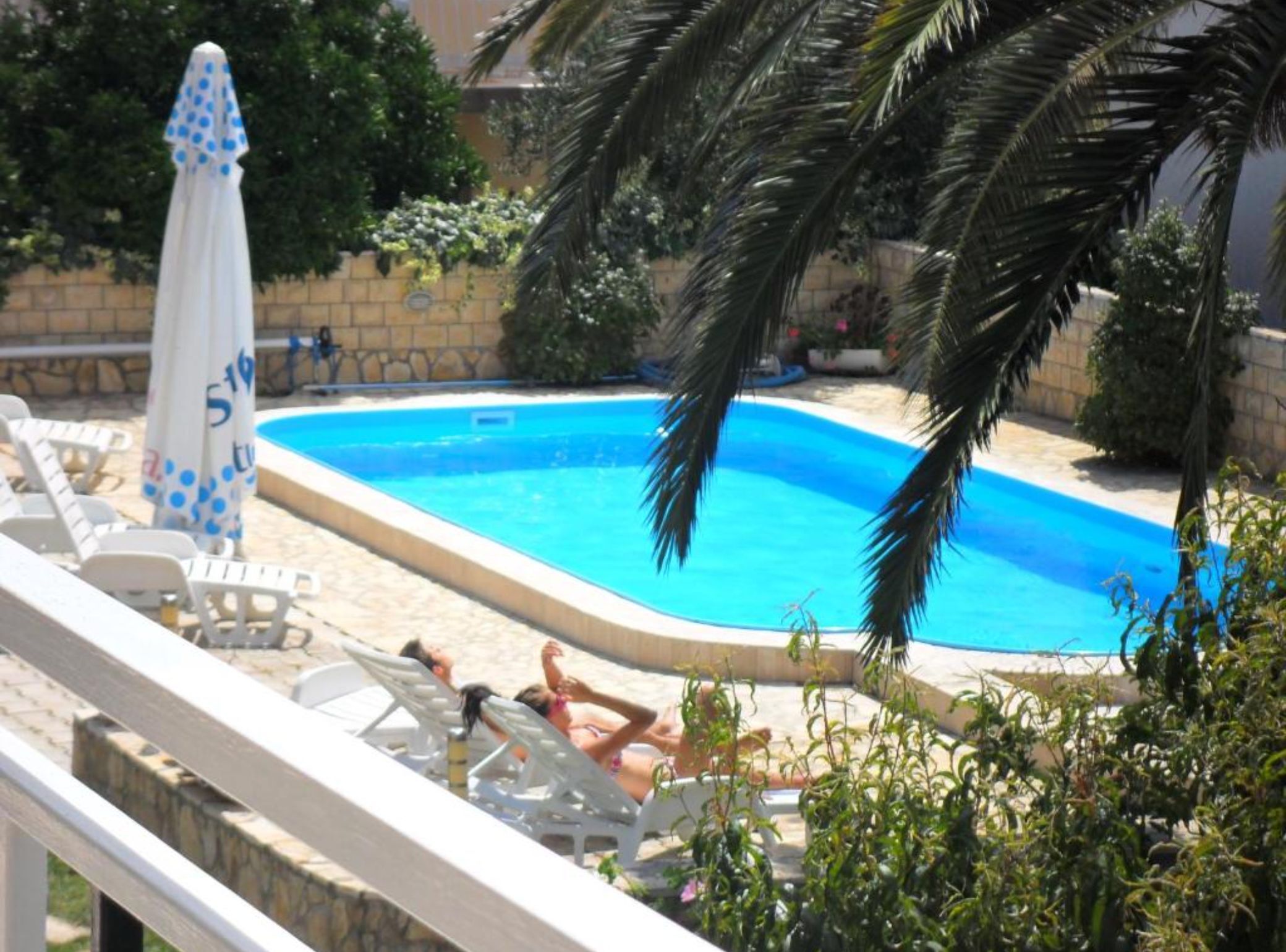 Una piscina con sillones de playa y sombrillas.
