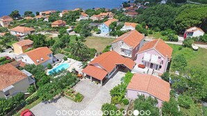 A coastal residential area with houses, a swimming pool, and a view of the sea. - Adriatic Guesthouse Balota With Shared Pool (Viganj)