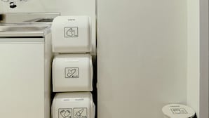 Eine moderne Küche mit weißen Schränken, einer Spüle und einem Mülleimer.