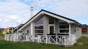 A modern house with a large deck, a chimney, and a spacious interior. - 4 Star Holiday Home in Grossenbrode (Grossenbrode)