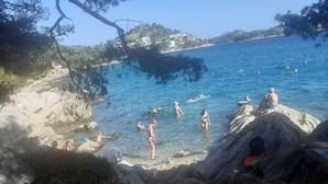 A coastal beach with rocky terrain and clear blue water. - Villa Ivan Vodice (Vodice)