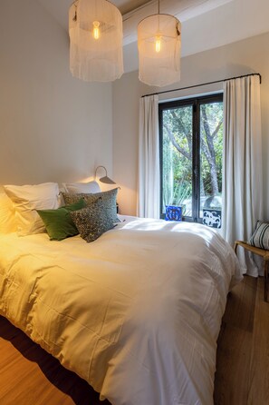 A bedroom with a large bed, two hanging light fixtures, a window with curtains, and a view of trees. - Provence Villa luxury, swimming pool, park 2ha, PDJ and Villa Manager included, 10 ' Aix (Aix-en-Provence)
