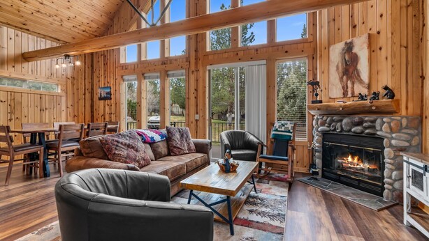 Un intérieur spacieux, avec des éléments en bois, une cheminée, des meubles en cuir et de grandes fenêtres.