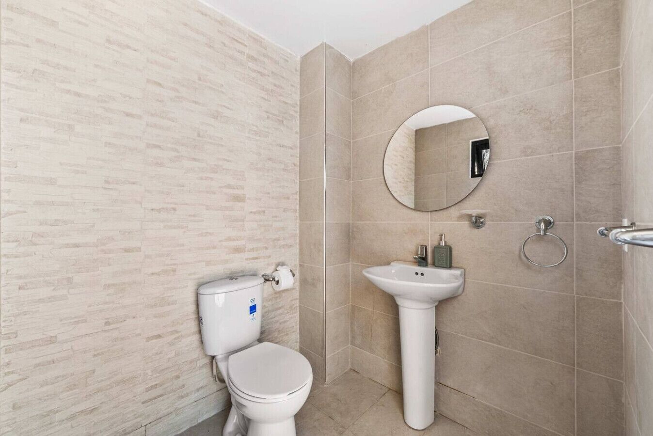 Ein Badezimmer mit Toilette, Waschbecken und Spiegel.