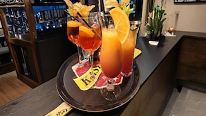 A bar area with three drinks on a tray, a refrigerator, and a plant on the counter. - Au Coeur D'alle by Belvilla-double Room (Vresse-sur-Semois)