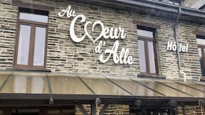 A building with a stone facade and a sign that reads "Au Coeur d'Alle" and "Hôtel". - Au Coeur D'alle by Belvilla-double Room (Vresse-sur-Semois)