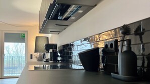Una cucina moderna con un'isola grande, elettrodomestici in acciaio inossidabile e vista sull'esterno.