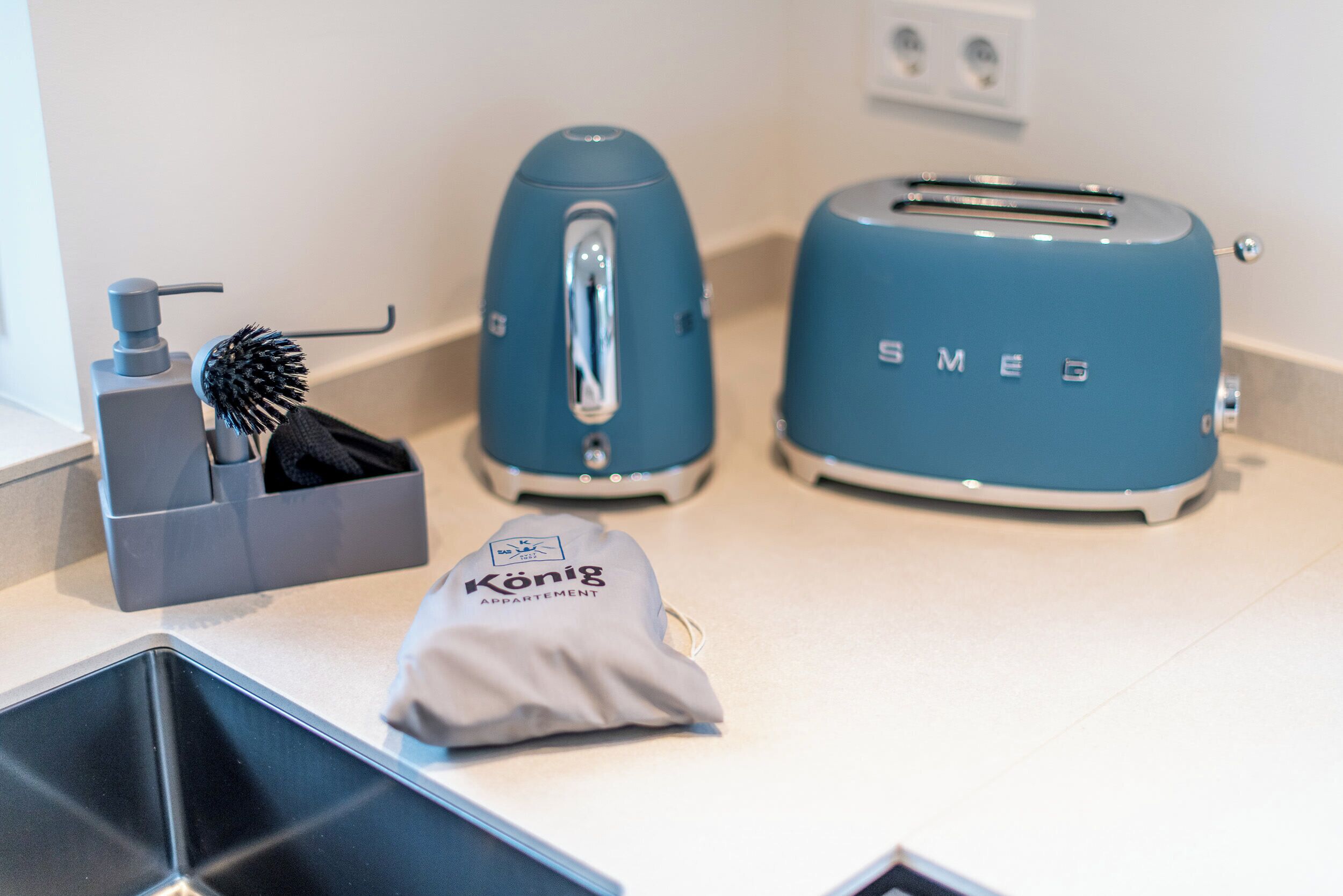 Eine Küchenzeile mit Toaster, Wasserkocher und Haarbürste.