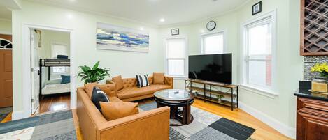 A living room with a sofa, TV, and a dining area.