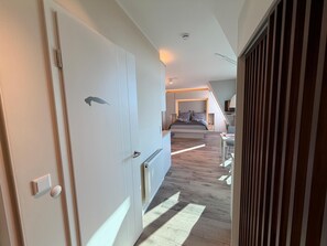Ein modernes Schlafzimmer mit Bett, Nachttischen und Deckenventilator.