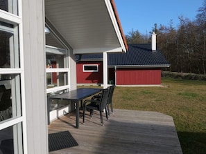 A modern house with a deck, a red shed, and a clear sky. - 4 Star Holiday Home in Grossenbrode (Grossenbrode)