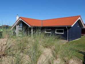 A house with a red roof, two windows, and a dark blue exterior. - 4 Star Holiday Home in Grossenbrode (Grossenbrode)